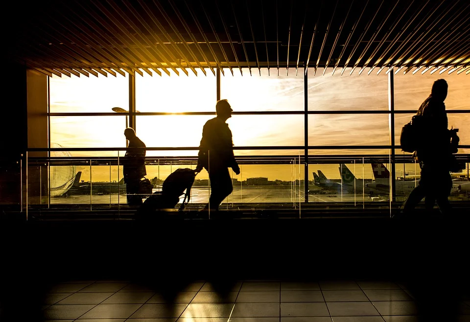 Menschen vor einem Sonnenuntergang auf dem Flughafen Auslandsreisekrankenversicherung WVK