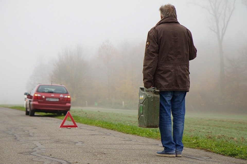 Mann mit Kanister vor stehengebliebenem Auto WVK KFZ Schutzbrief
